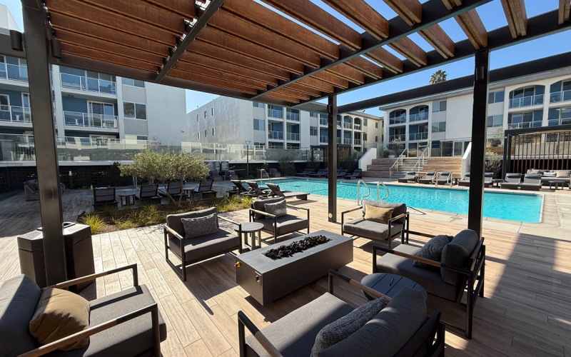 covered patio with couches and firepit