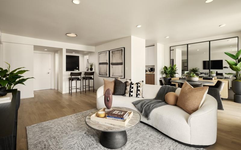 a living room with a couch and a coffee table near wet bar